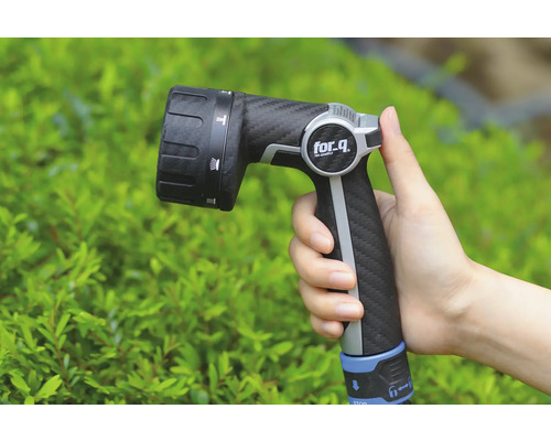 Een hand houdt een tuinspuit van for_q vast.