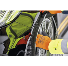 Sneeuwkettingen monteren op een autoband met handschoenen.