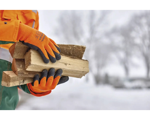 Persoon met werkhandschoenen die houtblokken draagt