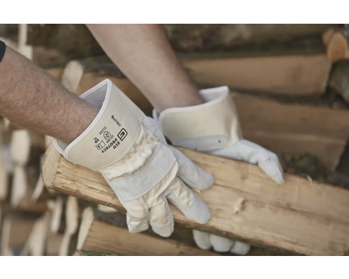 Een man met werkhandschoenen hanteert hout.