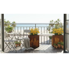 Balkonscène met tafel, stoelen, plantenbakken en uitzicht op zee voor een ontspannen sfeer