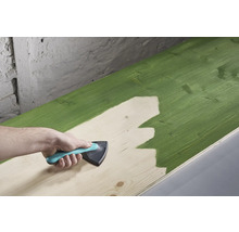 Een houten plank wordt geverfd met een schilderswerktuig.