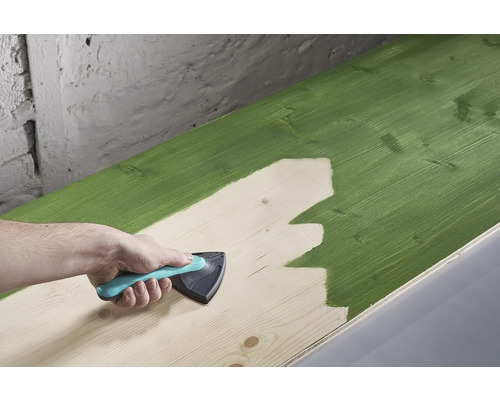 Een houten plank wordt geverfd met een schilderswerktuig.