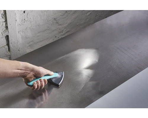 Hand gebruikt schuurblok om een metalen oppervlak glad te maken.