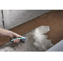 Hand met driehoekschraper die een metalen oppervlak reinigt