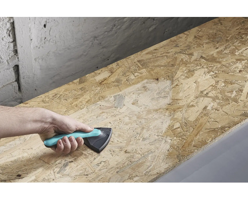 Een hand houdt een schuurblok vast en schuurt een houten plank.