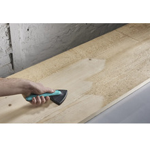 Hand schuurt houten plank met driehoekschuurmachine