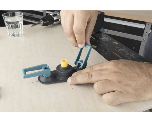 Een man bedient een gatzaag cirkelsnijder op een houten oppervlak