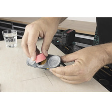 Man plaatst schuurkop in een verfbakje.