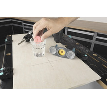 Scene van een werkbank met boormachine, glas water en tegelboor