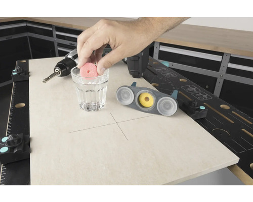 Scene van een werkbank met boormachine, glas water en tegelboor