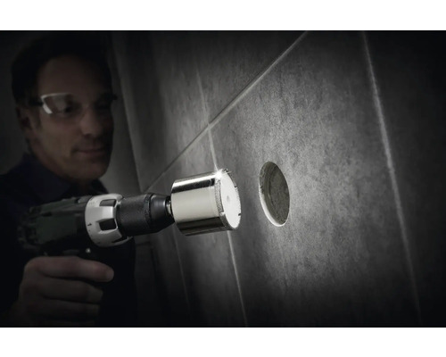 Man boort een gat in een tegel met een diamantboor.