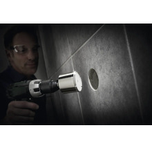 Man boort een gat in een tegel met een diamantboor.