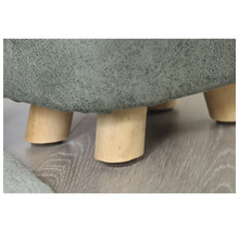 Detailopname van een hocker met bekleding en houten poten