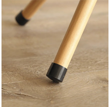 Detailopname van een stoelpoot met een zwarte vloerbeschermer op een houten vloer