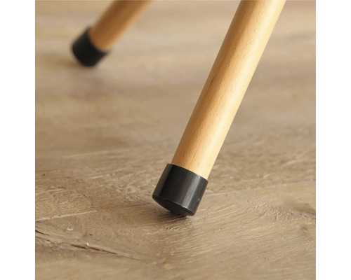 Detailopname van een stoelpoot met een zwarte vloerbeschermer op een houten vloer