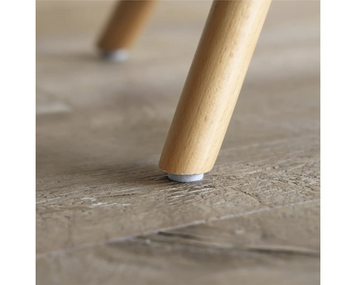 Close-up van een houten stoelpoot met vilten glijder op een houten vloer