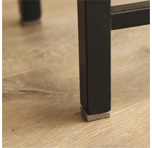 Detailopname van een zwarte meubelpoot met een vilten glijder ter bescherming van de vloer.