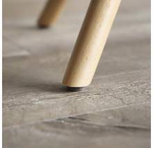 Close-up van een houten meubelpoot met vloerbeschermer.