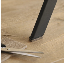 Viltglijder op een stoelpoot met schaar en stuk vilt op de vloer