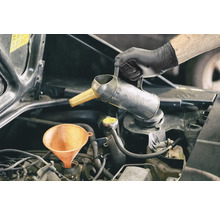 Motorolie wordt bijgevuld met trechter en oliekan