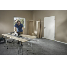 Man zaagt hout met een cirkelzaag op een werkbank in een kamer.