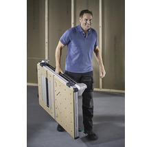 Een man draagt een ingeklapte werktafel.