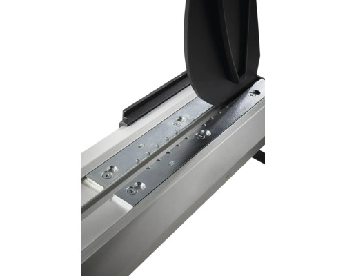 Close-up van een tegelsnijder met geleiderail, metalen platen en breekmechanisme.