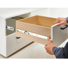 Opengetrokken lade in een witte kast met ladegeleider