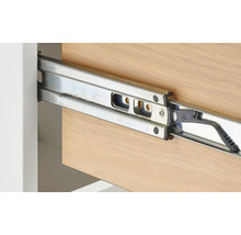 Detailopname van een metalen ladegeleider aan een houten lade