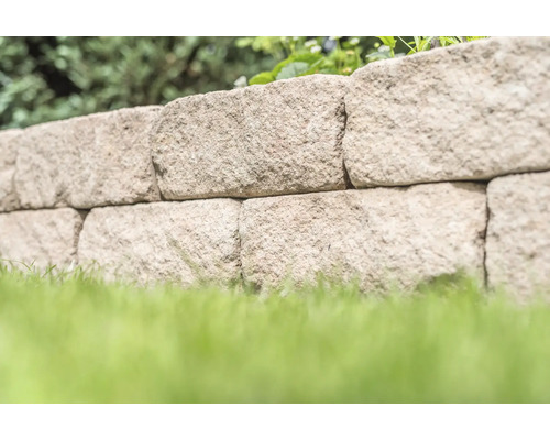 Natuurstenen muur met gazon in de tuin