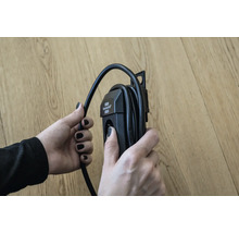 Een persoon houdt een haspel in zijn hand.