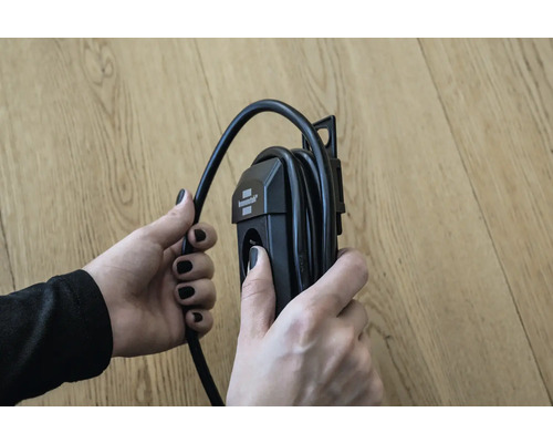 Een persoon houdt een haspel in zijn hand.