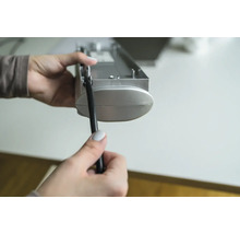 Een persoon houdt een jaloezie en een trekkoord in de hand.