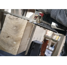 Een decoupeerzaag zaagt een houten plank.