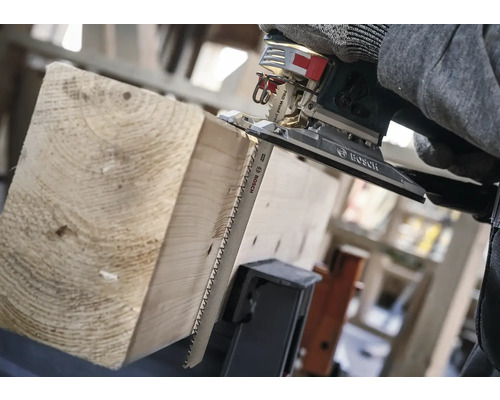 Een decoupeerzaag zaagt een houten plank.