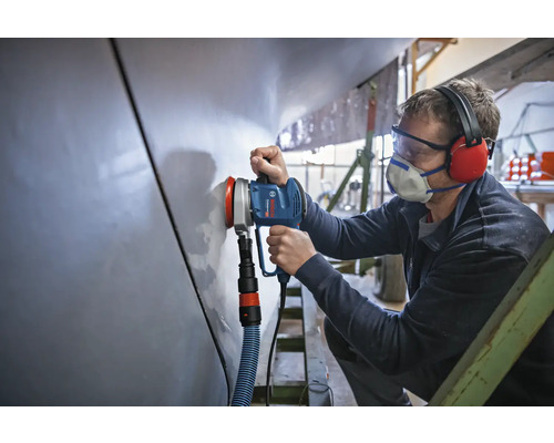 Ambachtsman gebruikt een excentrische schuurmachine om een oppervlak te schuren.