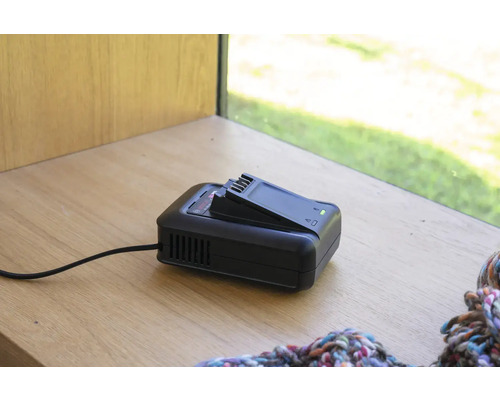 Acculader met accu op een houten oppervlak