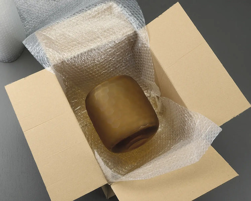 Bruine glazen vaas in een kartonnen doos met noppenfolie