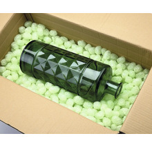 Decoratieve glazen fles in een doos met verpakkingschips