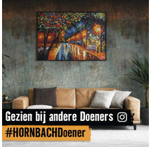 Woonkamer met bank en een ingelijste afbeelding aan de muur
