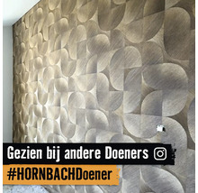 Close-up van een gestructureerd behang met geometrisch patroon op een muur.