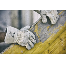 Een arbeider draagt Gebol Worker veiligheidshandschoenen tijdens het werken met een houten frame.