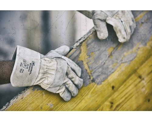 Een arbeider draagt Gebol Worker veiligheidshandschoenen tijdens het werken met een houten frame.