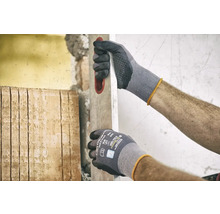 Man met werkhandschoenen en waterpas tijdens renovatiewerkzaamheden.