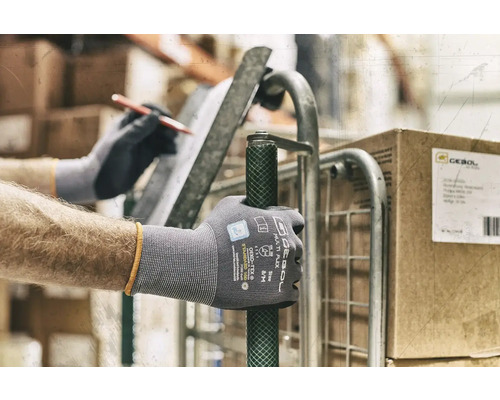 Een persoon met werkhandschoenen duwt een rolwagen.