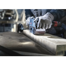 Ambachtsman schuurt hout met een bandschuurmachine