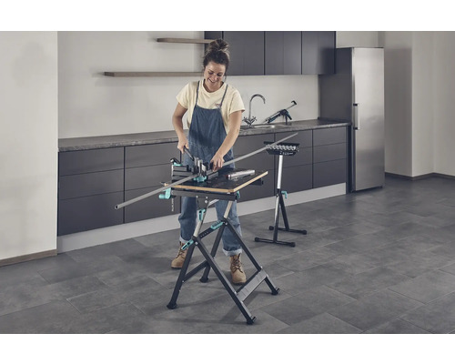 Vrouw werkt met een werkbank en een verstekzaag in een kamer.