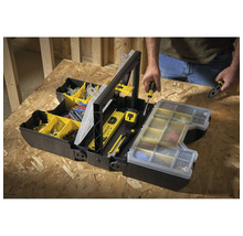 Open zwarte gereedschapskist met gereedschap en accessoires, met een persoon op de achtergrond.