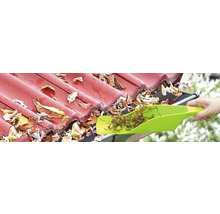 Dakgoot reinigen met een schep om bladeren te verwijderen